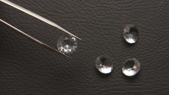 Diamond in tweezer at jeweller hand