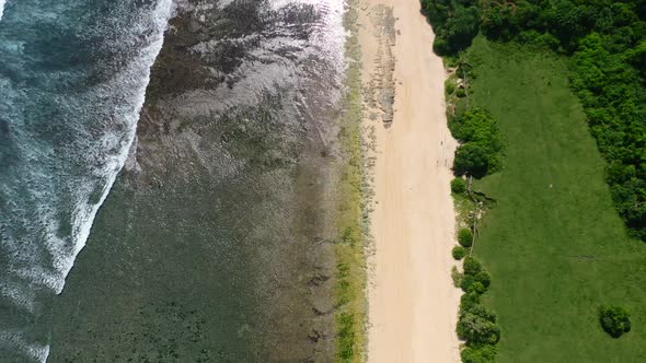 aerial top down view of empty white sand beach at Nyang Nyang in Uluwatu Bali on sunny day alt