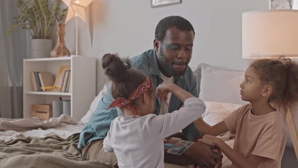 Little Sisters Applying Makeup on Dads Face alt