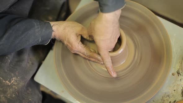 Potter Forms a Clay Product with Pottery Tools on a Pottery Wheel, Top View