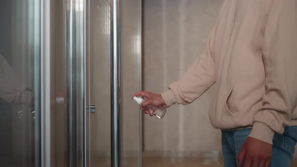 Closeup of Man's Hands Using a Sanitizer and a Wet Towel for Desinfection of Doors Knob alt