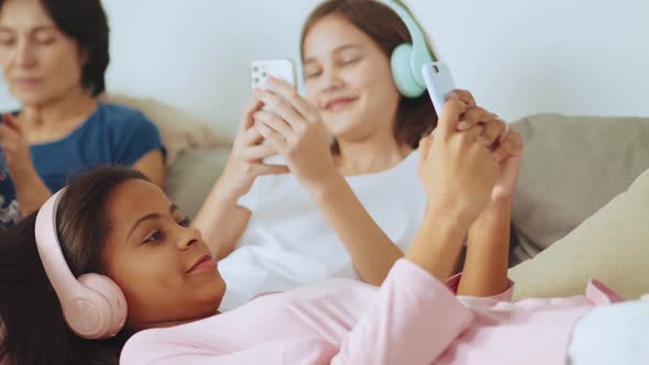 Cheerful multiethnic family typing by phones alt