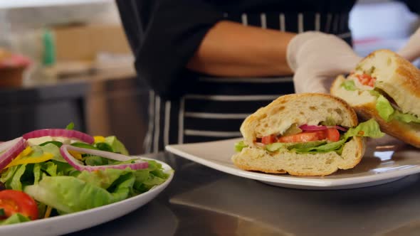 Chef preparing sandwich in commercial kitchen alt