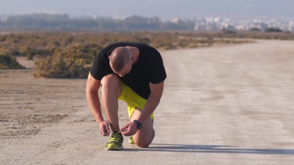 Sporty Man with Smartwatch Tying Trainers Shoe Laces Before Workout alt
