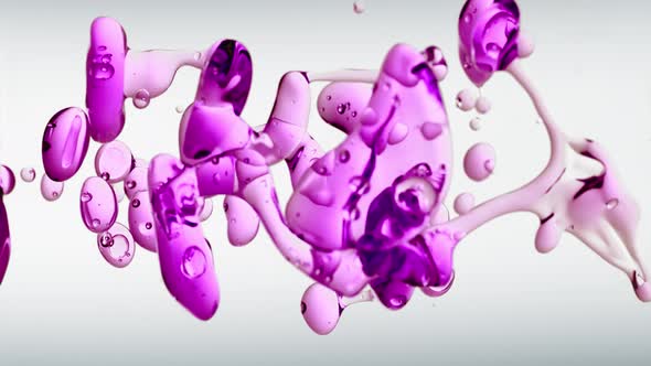 Macro Slow Motion Transparent Cosmetic Purple Oil Bubbles and Shapes on White Background
