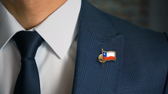 Businessman Walking Towards Camera With Country Flag Pin Chile alt