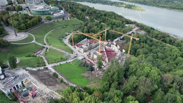 Aerial View Construction of a New Building with High Tower Cranes in Green Area alt