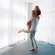 Young Man Holding Blonde Woman in Arms Spinning Around near Big French Window - VideoHive Item for Sale