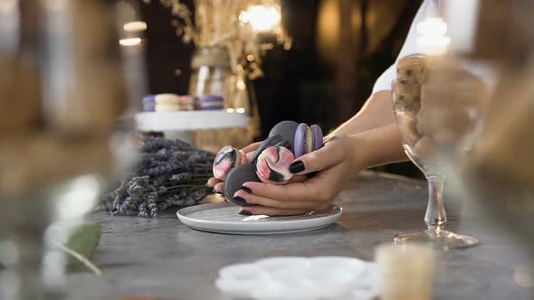 Female Chef Putting Macaroons Into the Plate alt