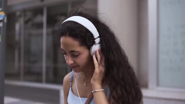 Happy Young Woman Listening To Music on Headphones and Dancing