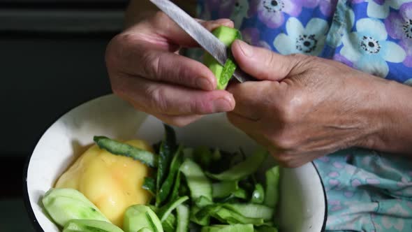 Lefthanded Elderly 80s Woman Hands Cut Cucumber Peels with Knife