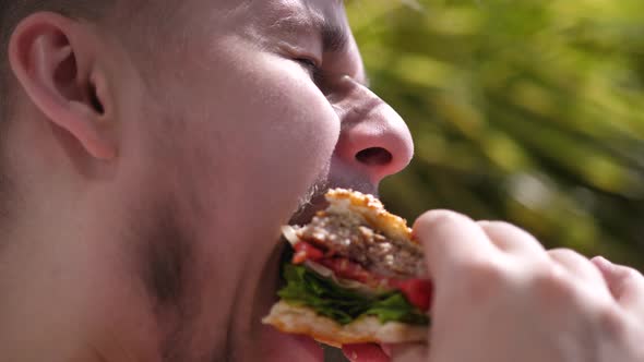 Bearded Man Is Eating a Hamburger