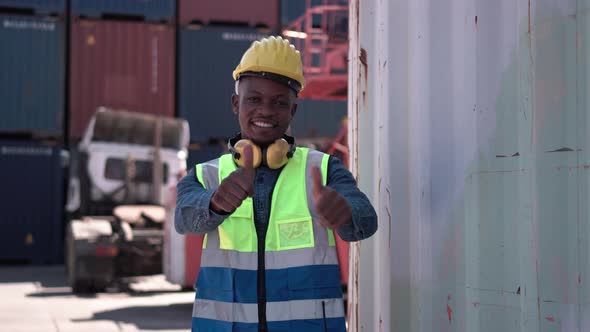 Factory worker man smiling with giving thumbs up at container cargo site