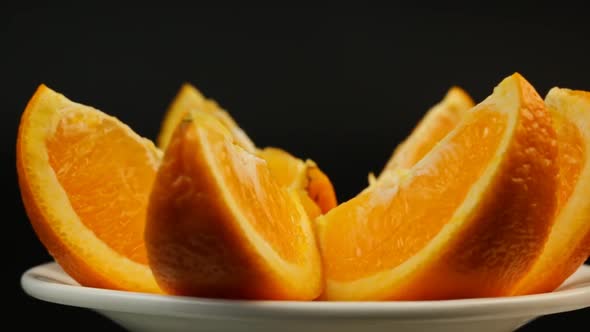 Fresh Orange In A White Plate Rotate On A Black Background