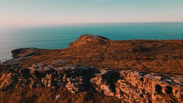 Monument to King Arthur in Britain Aerial view of a rock on a background of the sea