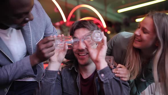 Happy friends having fun at bar with empty glasses, slow motion alt