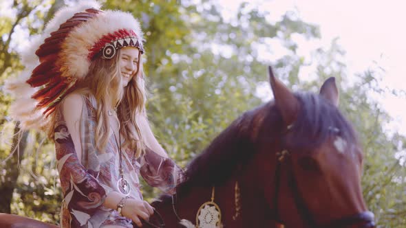 Young Woman In Headdress Riding Horse In Sunlit Forest alt