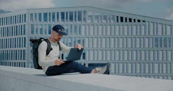 Hipster Man Work on Laptop in Business District alt