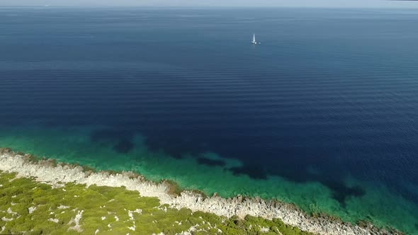 Aerial view of Lefkada island with a boat in the horizon, Greece. alt