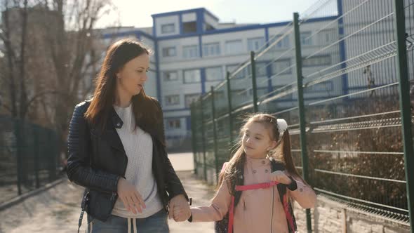 Mother and Young Daughter Go Home From School Together