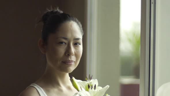 Woman holding fresh lilies, portrait alt