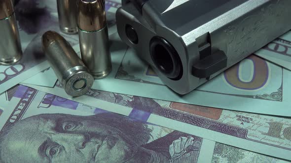 Close Up Of Pistol Bullets and Hundred Dollar Bills alt