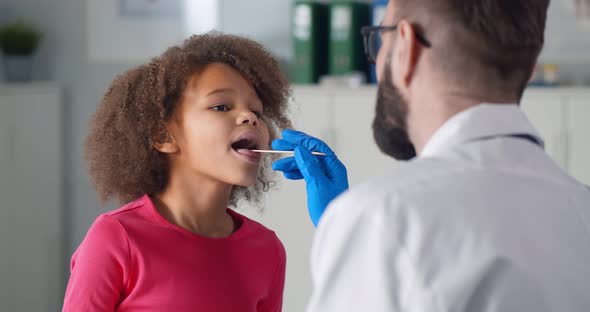 Children Doctor Examining Little Patient Throat in Clinic Office alt