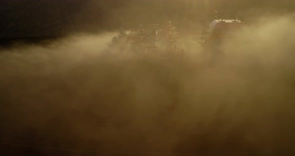 Aerial View of Tractor Cultivates Farm Field for Sowing alt