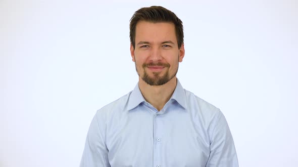 A Young Handsome Man Smiles at the Camera - White Screen Studio alt