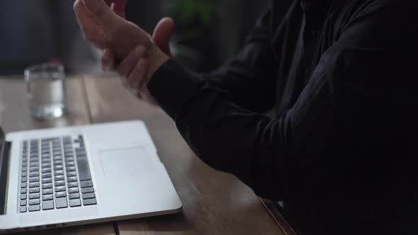 Closeup of Bearded Mature Adult Male Working Typing on Laptop Keyboard Experiences Pain in Wrist alt