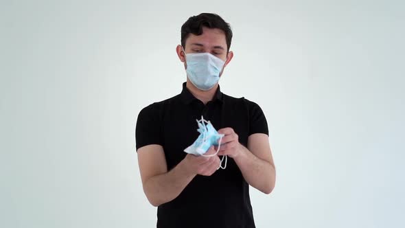 Portrait of Young Confident Man Wearing Protective Mask Counting Medical Masks. alt