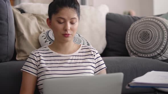Young Asian woman talking with someone during a video conference  alt