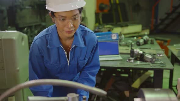 candid asian female Professional engineering wearing uniform and safety goggles alt