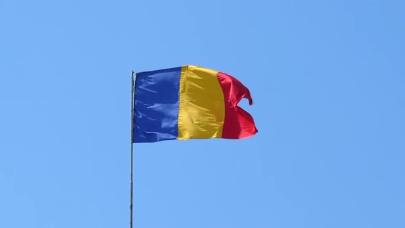 Romanian Tricolor Flag Fluttering in the Wind, Blue Sky Background. alt