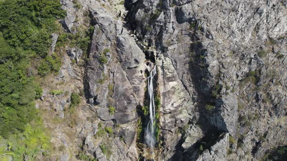 Aerial zoom in of natural waterfall named "Frecha da Mizarela" at Serra da Freita. Arouca geopark alt