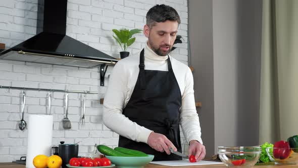Man chef in apron greets teaches housewife online videocall, sliced fresh cherry alt