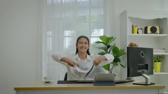 Slow motion, an Asian businesswoman throwing a piece of paper up top.