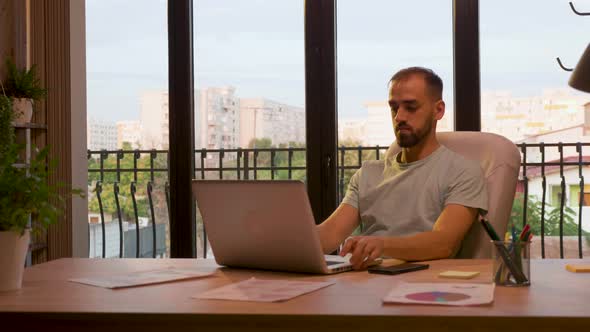 Successful CEO of Start Up Company Typing on the Laptop alt