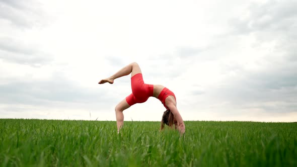 Slim Woman Practicing in Gymnastic Bridge  Yoga Asana Outdoors in Green Field alt