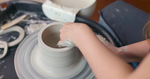 Closeup of Young Woman's Hands in Pottery Studio Using Pottery Wheel Handmade Ceramics Creative alt