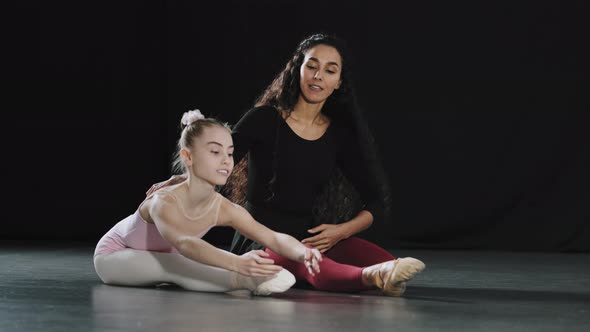 Adult Woman Coach Dancer Teacher Sitting on Floor with Girl Teenager Child Student Acrobat Beginner alt