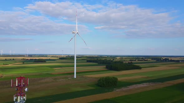 Aerial View of 5G Tower and Wind Energy Turbines in Summer alt