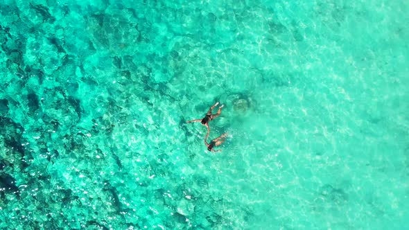 Girls tan on exotic resort beach trip by blue lagoon and clean sandy background of Lombok after sunr alt