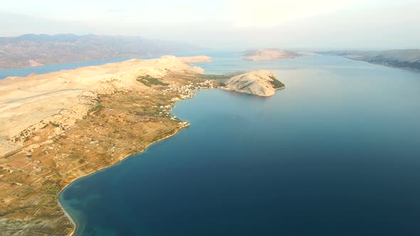 Flying above barren coast of Pag island a sunset, Croatia alt