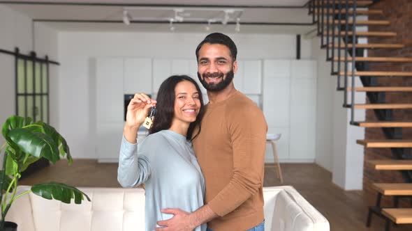 Young Married Couple Smiling Cheerfully and Showing Keys From a New Apartment alt
