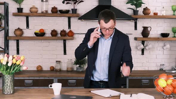 Angry Upset Businessman in Glasses and Suit Quarrels with Someone on the Phone While Standing in alt