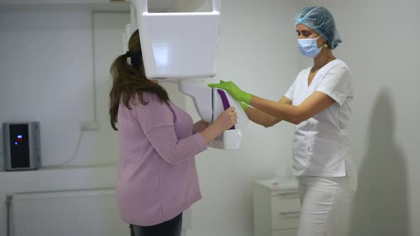 Side View Professional Doctor Using Dental Cone Beam Scanner Examining Plussize Woman in Hospital alt