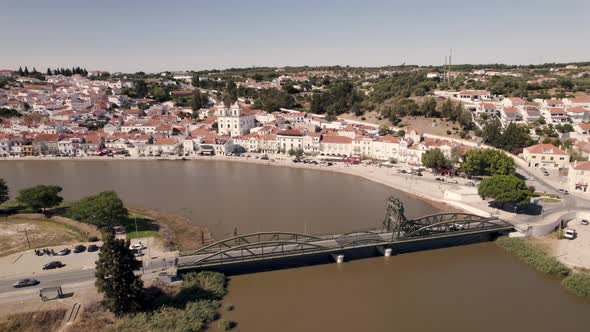 Alcacer do Sal bridge over Sado river and riverside cityscape. Aerial view alt