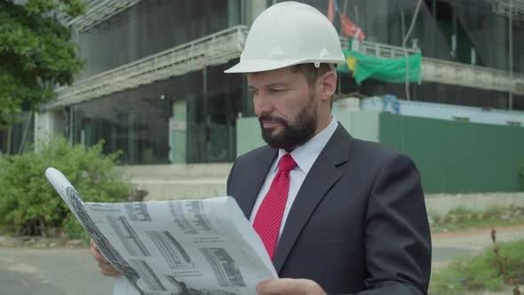 An Engineer Scientist and Developer at a Construction Site Checks on the Drawings at What Stage is alt