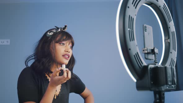 Young African American Woman Recording Video on Her Smartphone Illuminated By Ring Light While alt